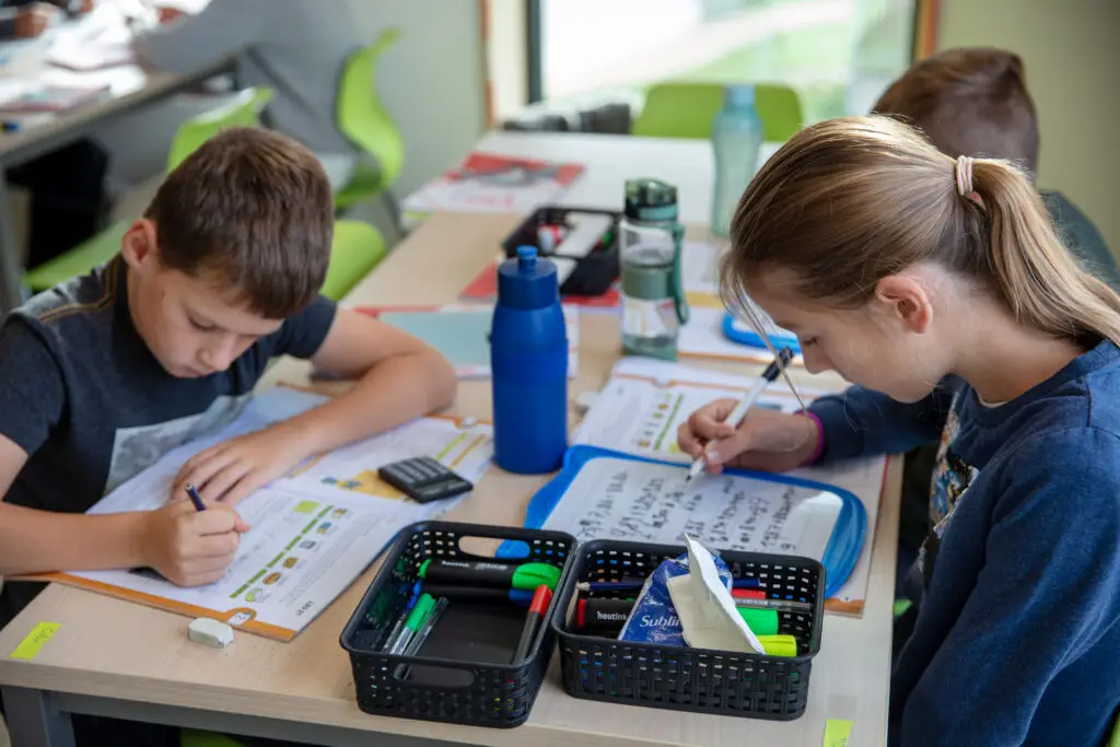 Kinderen maken een taak in de klas in de lagere school van basisschool Groei in Vlamertine